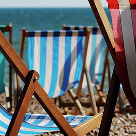 A Vendor Renting Deck Chairs Dozes by Luke MacGregor