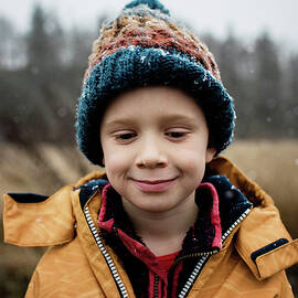 Boy Looking Out A Window Holding A Cereal Bowl At Christmas by Cavan Images