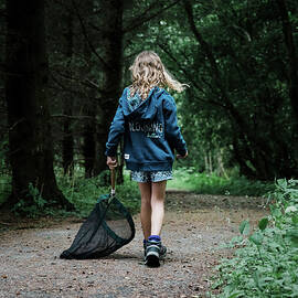 Child Bug Hunting With A Net In The Forest In Scotland by Cavan Images