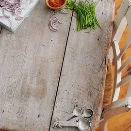 Chives, Red Onions, Paprika Powder And Measuring Spoons On A Wooden Board by Gareth Morgans