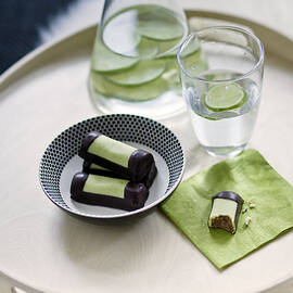 Chocolates In Bowl And Napkin, Water And Lime Slices In Pitcher And Glass by Jalag / Angelika Lorenzen