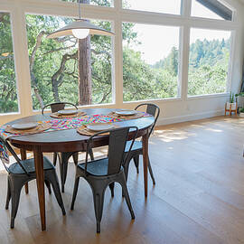 Dining Room Set For Four With View Of Trees Out Large Windows by Cavan Images / Liz Celeste