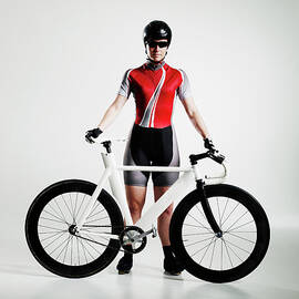Female Cyclist Standing Next To Track by Thomas Barwick