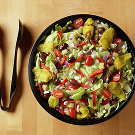 Greek Salad With Plastic Tongs Shot On Butcher Block Table From Above by Michael S. Harrison