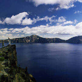 Man And Tree At The Edge Of Crater Lake by Danielle D. Hughson