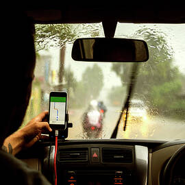 Man Using Navigation Map On Mobile Phone While Sitting In Car by Cavan Images