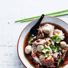 Overhead View Of Boat Noodles In Bowl With Chopsticks And Soup Spoon by Brett Stevens