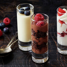Still Life With Three Desserts In Glasses With Raspberry And Blackberry Garnish by Danielle Wood