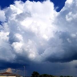 Towering, gigantic rain clouds darkening the sky by Daniella Edington