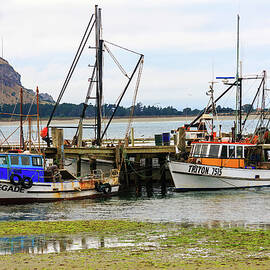  Fishing boats moored at a pier by Kevin Hellon