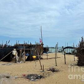 Wood and bamboo palm leaf thatched shacks by seaside in fishing village Pattani Thailand  by Imran Ahmed