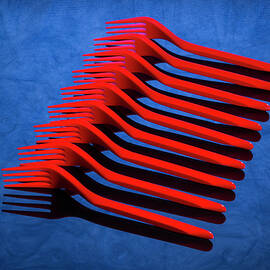 Abstract still life with red forks on blue table by Valentin Ivantsov