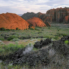 Ancient lava flows and colorful soaring sandstone cliffs are found at Utah's Snow Canyon State Park. by Larry Geddis