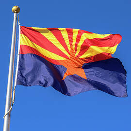 Arizona state flag waving in the wind against a cloudless blue sky by Miroslav Liska
