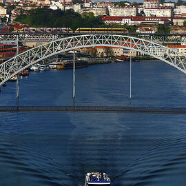 Cruise boat passing the Dom Luis I Bridge Porto Portugal by James Brunker