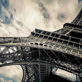 Eiffel Tower with blue sky and cloud background. Low angle view  by Jane Rix
