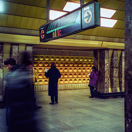 Man Reading While Waiting While Reading inside the  Prague Subway Station Far Underground by Matthew Bamberg