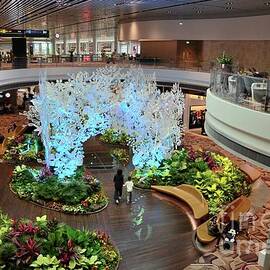 Passengers move around a green garden relaxing area inside Changi Airport terminal Singapore by Imran Ahmed