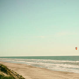People on the andy ocean coastline with parafoil kite by Monica Novelle