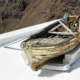 Santorini, Greece A wrecked Boat on a roof at Firostefani near Fira on a greek island named Santorini. In the background is Skaros Rock mountain of Imerovigli by Arpan Bhatia