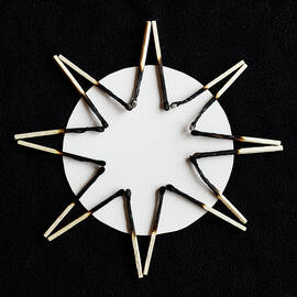 SunBurn - partially burned matchsticks on black and white background by Peter Herman