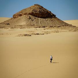 Taking a walk in the desert near Siwa, Egypt - man in white shirt walking on brown sand in the morning - Siwa Desert, Agypten by Julien