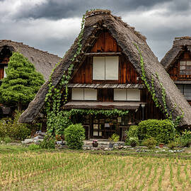Three houses on a cloudy day in the village of Shirakawa, Japan by Rick Neves