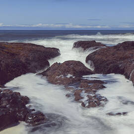 Wave surging upon a rocky shore by Jeff Swan