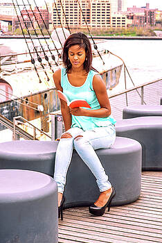 Alexander Image - Young African American Woman reading book, relaxing by river in Alexander Image - Young African American Woman reading book, relaxing by river in