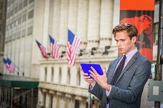 Alexander Image - Young businessman reading tablet computer on street in New York 15041211 Alexander Image - Young businessman reading tablet computer on street in New York 15041211