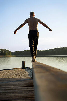 Wall Art - Photograph - A Man Balances Barefoot On A Rail #1 by Lars Schneider