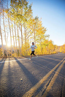 Wall Art - Photograph - A Woman Enjoying A Run On A Crisp Fall #1 by Mike Schirf