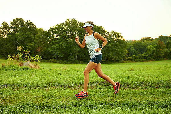 Wall Art - Photograph - A Woman Running Through A Field #1 by Josh Campbell