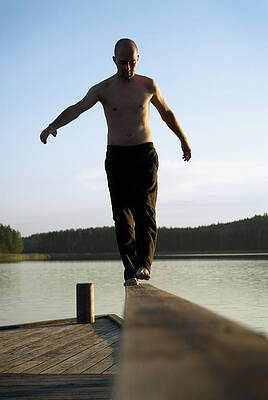 Wall Art - Photograph - A Man Balances Barefoot On A Rail by Lars Schneider