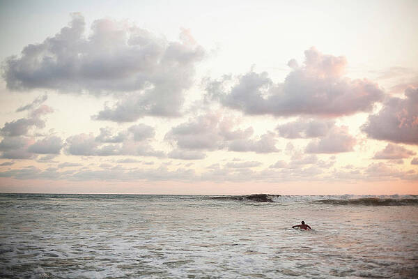 Wall Art - Photograph - A Man Paddles Out To Catch The Last by Michael Hanson