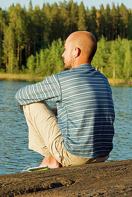 Wall Art - Photograph - A Man Sitting At The Edge Of A Lake by Lars Schneider