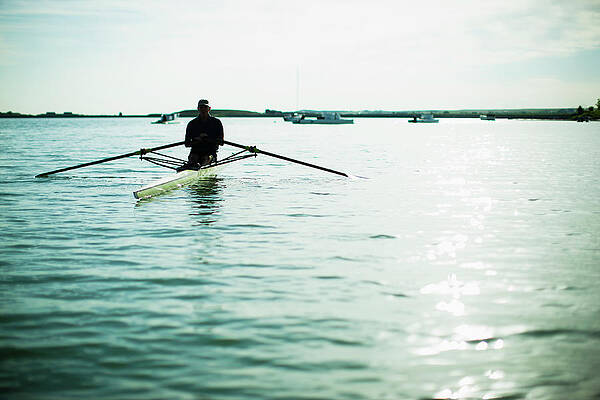 A Mature Man In A Rowing Boat On The Print by Mint Images/ Jamie Kripke