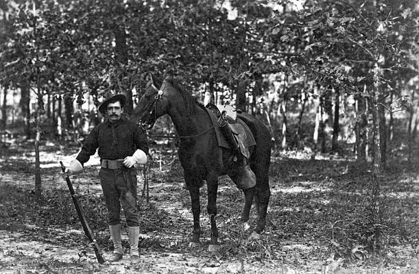 Wall Art - Photograph - A member of the cavalry poses standing in front of his horse by Underwood Archives