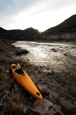 Wall Art - Photograph - A Whitewater Kayak Rests On The Shore by Kyle George