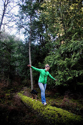 Wall Art - Photograph - A Woman Balances On A Moss-covered Log by Michael Hanson