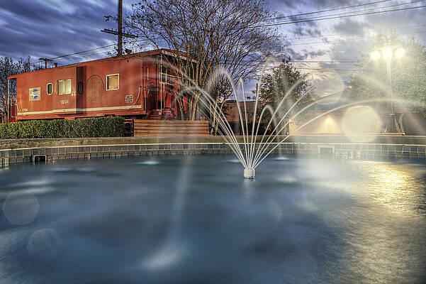 Wall Art - Photograph - Caboose and Fountain at Dusk by Jason Politte