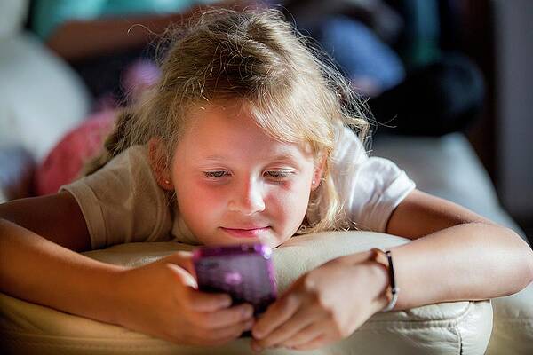 Wall Art - Photograph - Girl Lying On Front Using A Smartphone by Science Photo Library