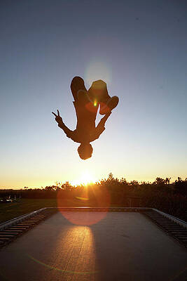 Wall Art - Photograph - Man Doing Backflip On Trampoline by Ubald Rutar