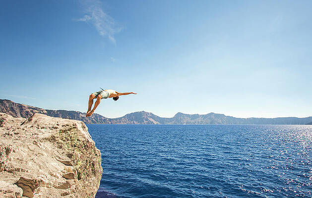 Wall Art - Photograph - Man Doing Backflip While Cliff Jumping by David Hanson