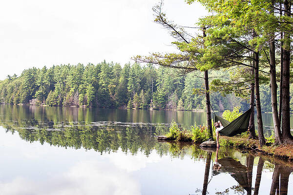 Wall Art - Photograph - Man Lies In Hammock On A A Lake by Monica Donovan