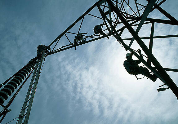 Wall Art - Photograph - Silhouetted Technicians Servicing A Power Line by Science Photo Library