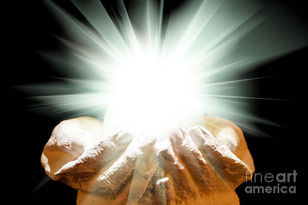 Spiritual light in cupped hands on a black background by Simon Bratt Spiritual light in cupped hands on a black background by Simon Bratt