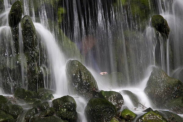 Visitor stands behind the Grand Waterfall in park Sonsbeek in Arnhem Netherlands by Ronald Wilfred Jansen