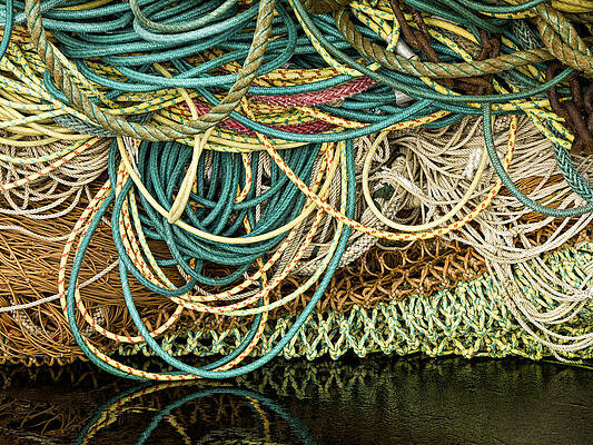 Pile of old and used fishing nets colored, floating and blue rope