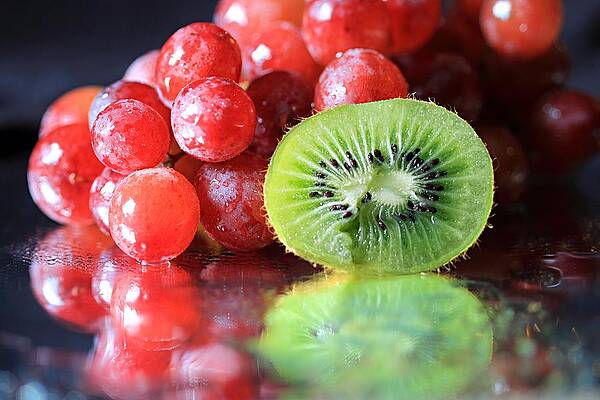 Wall Art - Photograph - Sliced Kiwi and Grapes by Angela Murdock